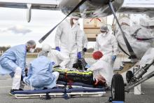 Des équipes médicales évacuent un patient atteint du Covid-19 vers un hôpital où des lits de réanimation sont disponibles, le 27 octobre 2020 à l'aéroport de Bron, près de Lyon