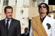Le président français Nicolas Sarkozy (g) est accueilli par son homologue libyen Mouammar Kadhafi, lors de la son arrivée à Tripoli, le 25 juillet 2020