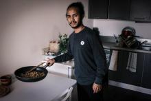 L'étudiant malgache Mampiandry Randrimiharisoa cuisine dans son appartement à Bron, un quartier de Lyon, le 25 novembre 2020