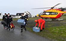 Des soignants du SDIS débarquent d'un hélicoptère avec deux caisses contenant des vaccins anti-Covid-19 sur l'île de Hoëdic dans le Morbihan, le 29 janvier 2021