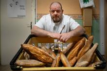 Le boulanger Stéphane Ravacley qui a obtenu la régularisation de son apprenti guinéen au prix d'une grève de la faim pose devant ses pains, le 6 janvier 2021 à Besançon (Doubs)