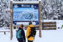 Des personnes regardent la carte du domaine skiable de Villard-de-Lans, le 5 janvier 2021 en Isère
