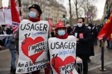 Des manifestants dénoncent les conditions de travail des professionnels de santé et de l'action sociale et défendent l'hôpital public, lors d'une manifestation le 21 janvier 2021, à Paris
