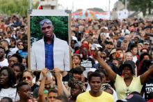 Une personne tient un portrait lors d'une marche, le 21 juillet 2018 à Paris, à la mémoire d'Adama Traoré, décédé il ya deux ans à la suite de son interpellation