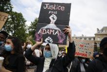 Un manifestant porte une pancarte "Justice pour Adama" lors d'un rassemblement contre les violences policières le 13 juin 2020 à Paris