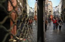 Des piétons dans une rue où les commerces non essentiels ont fermé, le 20 mars 2021 à Paris