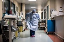 Une soignante enfile une blouse de protection avant d'entrer dans l'unité de soins intensifs du Centre hospitalier privé de l'Europe, le 25 mars 2021 au Port-Marly, près de Paris