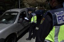 Un policier espagnol contrôle les résultats des tests PCR des automobilistes voulant se rendre en Espagne, à la frontière entre la France et l'Espagne, au Perthus, le 30 mars 2021