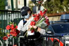 Un homme apporte des fleurs à l'hôtel de police de Rambouillet, le 26 avril 2021