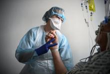 Une soignante s'occupe d'un patient infecté par le Covid-19 qui se trouve en soins intensifs à l'hôpital européen Georges-Pompidou à Paris, le 6 avril 2021