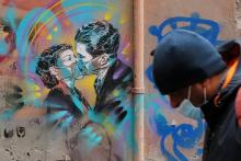 Graffiti d'un couple s'embrassant avec des masques