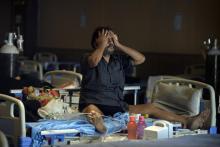 Un patient atteint du Covid-19 est assis sur un lit dans une salle de banquet transformé en centre de soins temporaire à New Delhi le 10 mai 2021