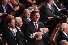 Le parlementaire démocrate Eric Swalwell (c), son bébé dans les bras, lors de la cérémonie d'investiture de la Chambre des représentants, le 3 janvier 2019 à Washington