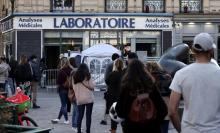 Des personnes font la queue pour subir un test PCR du coronavirus devant un laboratoire d'analyses à Paris, le 31 mars 2021