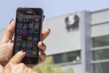Une femme montre son téléphone devant le siège de l'entreprise NRO, qui a conçu un logiciel espion, le 28 août 2016 à Herzliya, en Israël.