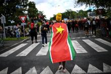 Un manifestant couvert du drapeau régional de la Guadeloupe lors d'un rassemblement contre les restrictions sanitaires à pointe-à-Pitre, le 27 novembre 2021