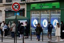 Des personnes font la queue le 6 janvier 2022 devant une pharmacie à Paris pour un test de dépistage du Covid-19
