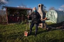 Christiane Dantzer pose dans son jardin où elle fait pousser fruits et légumes qui lui permettent d'être pratiquement auto-suffisante en la matière, le 11 janvier 2022 à Sélestat, dans le Bas-Rhin