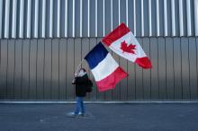 Une participante à un "convoi de la liberté" brandit les drapeaux français et canadien le 9 février 2022 à Nice