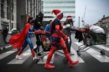 Des membres d'un collectif déguisés en super-héros, dont sa fondatrice Océane Gaixet (C), poussent des chariots remplis de vivres et de vêtements pour les sans-abris, le 8 janvier 2022 à Bordeaux