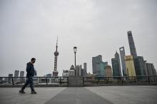 Un homme marche sur le Bund, artère historique de Shanghai le 28 mars 2022