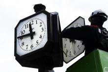 Un agent effectue manuellement le changement d'heure à l'heure d'été sur une horloge à Paris, le 26 mars 2021