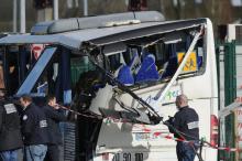 Des policiers autour d'un autocar de transport d'enfants cisaillé par un camion-benne le 11 février 2016 à Rochefort, un accident qui a fait six morts parmi les adolescents