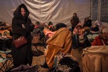 Des réfugiés ukrainiens se reposent dans une tente après avoir traversé la frontière ukrainienne avec la Pologne, au poste frontière de Medyka, dans le sud-est de la Pologne, le 11 mars 2022