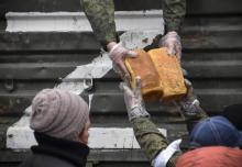 Des soldats et bénévoles russes distribuent du pain aux habitants de Marioupol, la ville portuaire dévastée du sud de l'Ukraine, le 12 avril 2022