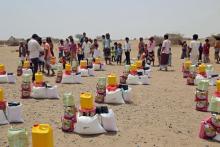 Distribution de rations alimentaires dans un camp de déplacés, dans la province occidentale de Hodeida, le 29 mars 2022 au Yémen