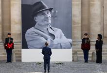 Le président Emmanuel Macron devant le portrait géant de l'acteur Michel Bouquet, décédé à l'âge de 96 ans, lors de l'hommage qui lui a été rendu le 27 avril 2022 aux Invalides à Paris.