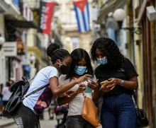 Des Cubains consultent leur téléphone mobile, le 14 juillet 2021 à La Havane