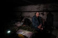 Natalia Gueorguievna, 70 ans, assise sur son lit dans la cave où elle est vit, avec six autres personnes, depuis plus de deux mois, le 14 mai 2022 à Lyssytchansk, tout près de la ligne de front dans l