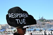 Un manifestant avec une pancarte "Respirer tue" lors d'une manifestation contre la pollution de l'air à Marseille, le 11 juin 2022