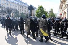 Des policiers français se tiennent en groupe sur la Place de la Nation au milieu d'affrontements avec des manifestants en marge du rassemblement annuel du 1er mai (Fête du travail), marquant la Journée internationale des travailleurs, à Paris, le 1er mai 2022.