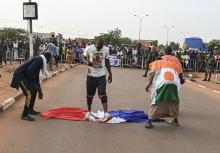 Niamey, 1er septembre 2023 - Des Nigériens piétinent le drapeau français lors d'une manifestation devant la base militaire française.