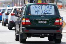 "Taxe de pet, mon cul", peut-on lire sur une pancarte au dos d'une voiture lors d'une manifestation