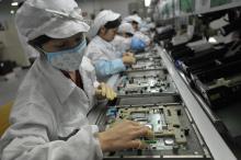Cette photo d'archive prise le 27 mai 2010 montre des ouvriers chinois dans l'usine Foxconn à