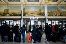 Des voyageurs font la queue devant l'entrée d'une boutique SNCF à la Gare de Lyon, lors d'une grève