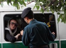 Un policier iranien devant une femme arrêtée en raison de ses vêtements, le 23 juillet 2007, à