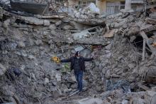 Un homme dans les décombres d'un immeuble d'Antakya détruit par le séisme, en Turquie, le 15 février